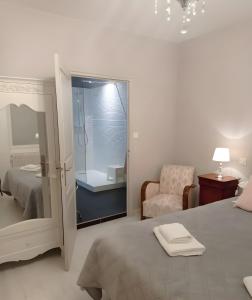 a bedroom with a bed and a chair and a mirror at Entre Brionnais Et Bourbonnais in Montaigüet-en-Forez