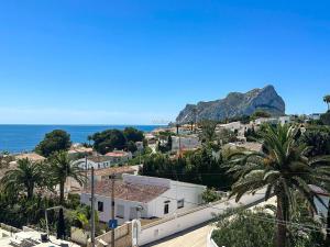 a view of a town with palm trees and the ocean at Villa Peñón View in Calpe