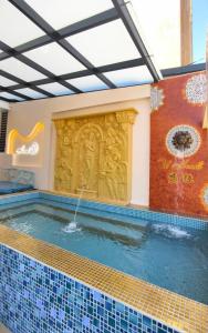 a swimming pool with a fountain in a building at u hend villa in Hengchun South Gate