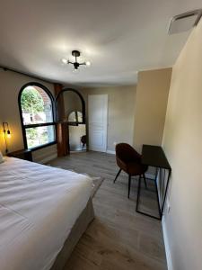 a bedroom with a bed and a desk with a chair at Suite Rivière in Lèves