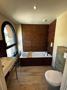 a bathroom with a tub and a toilet and a sink at Suite Rivière in Lèves +8 photos