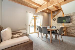 a living room with a table and chairs and a tv at Kirowy Domek I in Kościelisko