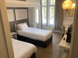 a hotel room with two beds and a window at The Angel Hotel in Cardiff +41 photos