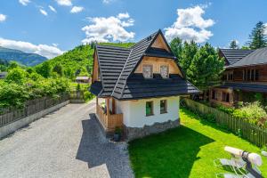 a small house with a black roof at Kirowy Domek I in Kościelisko