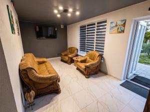a living room with two chairs and a television at Апарт Стефанія in Skhidnitsa