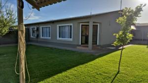 a house with a green lawn in front of it at Prince and Pooch Self Catering in Windhoek