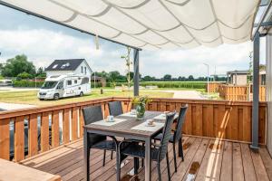a deck with a table and chairs with a rv in the background at Zwerg Nase in Dörverden