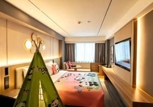 a hotel room with a large bed with a childs bedroom at Orange Hotel Beijing Yansha Landmark River in Beijing