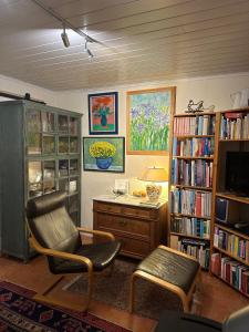 a living room with a chair and a desk and book shelves at Ferienhaus Ahrenshoop in Ahrenshoop