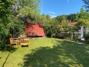 a yard with two chairs and a red roof at Ferienhaus Ahrenshoop in Ahrenshoop