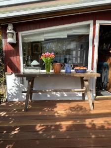 a picnic table with flowers on it on a porch at Ferienhaus Ahrenshoop in Ahrenshoop
