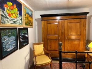 a room with a chair and paintings on the wall at Ferienhaus Ahrenshoop in Ahrenshoop