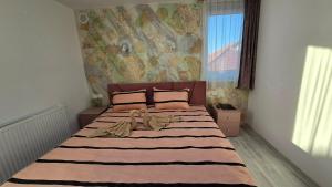 a bedroom with a large bed with a large window at Casa MADE in Turda