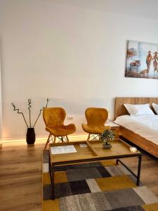 two chairs and a coffee table in a bedroom at Contemporary Studio with Balcony - New Building in Bucharest