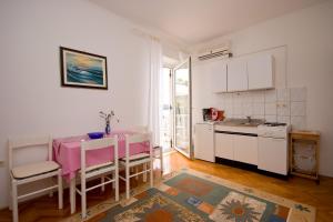 a small kitchen with a table and a pink table at Apartments Vila Miranda on the beach in Barbat na Rabu