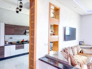 a living room with a couch and a kitchen at Petit-villa avec piscine in Marrakesh