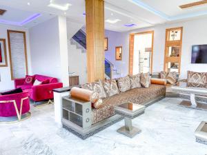 a living room with a couch and red chairs at Petit-villa avec piscine in Marrakesh