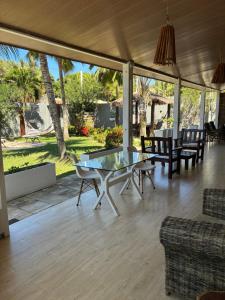 a living room with a glass table and chairs at Pousada Sapê in Praia do Frances