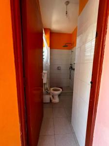 a bathroom with a toilet and a shower in it at PRIMESHADE GUESTHOUSE in Malindi +10 photos