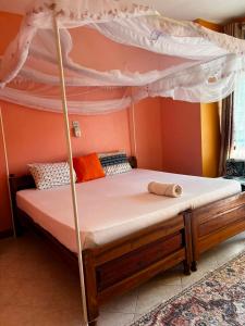 a bed with a canopy in a room at PRIMESHADE GUESTHOUSE in Malindi