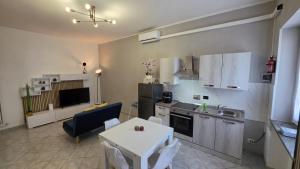 eine Küche und ein Wohnzimmer mit einem Tisch und einem Sofa in der Unterkunft Dimora Marsè - Indipendente con area esterna privata in Moncalieri