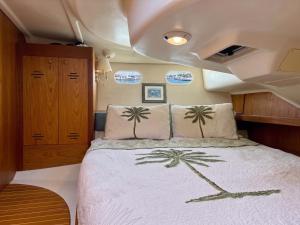 a bedroom with a bed with palm trees on it at Elegant Sailboat Stay in Key West +24 photos