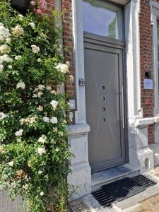 a door to a brick house with flowers at Station 33 in Spa