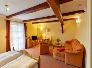 ein Schlafzimmer mit einem Bett und ein Wohnzimmer in der Unterkunft Hotel Gut Voigtlaender in Blankenburg