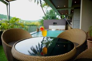 a glass table with two drinks on it on a patio at SOLARAA iNN in Anjuna
