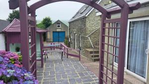an archway leading to a patio with a blue door at Sive Budget Accommodation in Cahersiveen