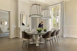 a woman standing in a dining room with a table and chairs at COMO Cordeillan-Bages in Pauillac