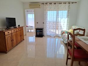 un soggiorno con la TV su una cassettiera di legno di Apartamento Playaestrella a Vícar