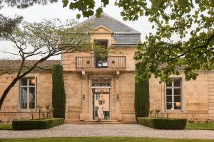 a woman standing in the doorway of a house at COMO Cordeillan-Bages in Pauillac