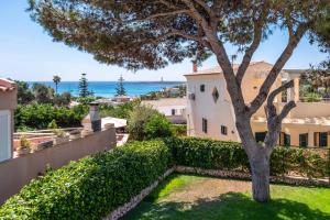 a view of the ocean from a house with a tree at Villa Sol de Flandes in Punta Prima