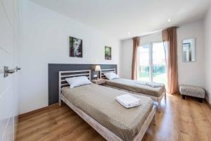 a bedroom with two beds and a window at Villa Sol de Flandes in Punta Prima +14 photos