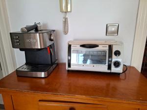 un forno a microonde appoggiato su un tavolo accanto a una macchina per il caffè di Apartamento Playaestrella a Vícar