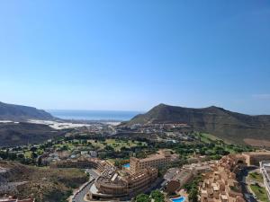 una vista aerea di una città con montagne e oceano di Apartamento Playaestrella a Vícar