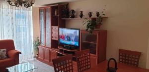 a living room with a television in a entertainment center at Piso de Perlío in Fene