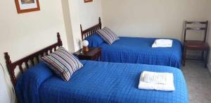 two beds in a room with blue sheets at Piso de Perlío in Fene