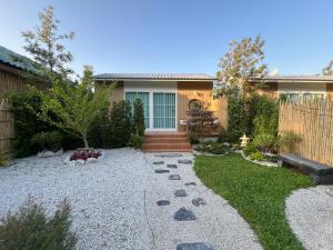 a backyard with a house with a gravel yard at After Beach House Phla Resort in U-Tapao