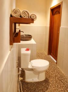 a bathroom with a white toilet and a sink at Lombok eco Bungalow in Gili Gede +11 photos