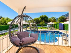 a swing on a balcony next to a swimming pool at Villa Delfin in Ortaca