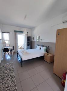 a bedroom with a large white bed and a table at Seaview Studio in Gázion