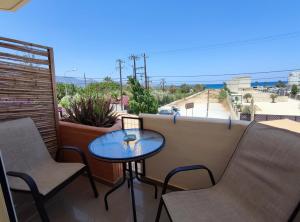 a table and chairs on a balcony with a view at Seaview Studio in Gázion +6 photos