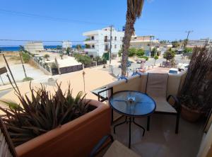 a balcony with a table and a view of a street at Seaview Studio in Gázion