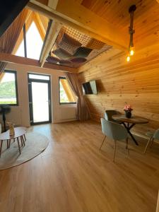 a large living room with wooden ceilings and a table and chairs at A Frame 2 Transalpina in Sebeş