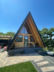 a cabin with a pitched roof with a patio at A Frame 2 Transalpina in Sebeş