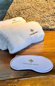 a pair of towels sitting on top of a table at Chalé da Árvore - Refúgio das Videiras in Moeda
