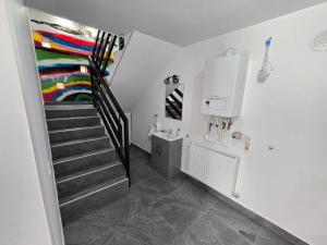 a staircase in a white room with a painting on the wall at Casa MADE in Turda +58 photos
