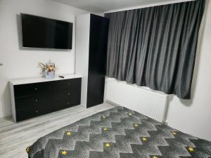a bedroom with a bed and a flat screen tv at Casa MADE in Turda